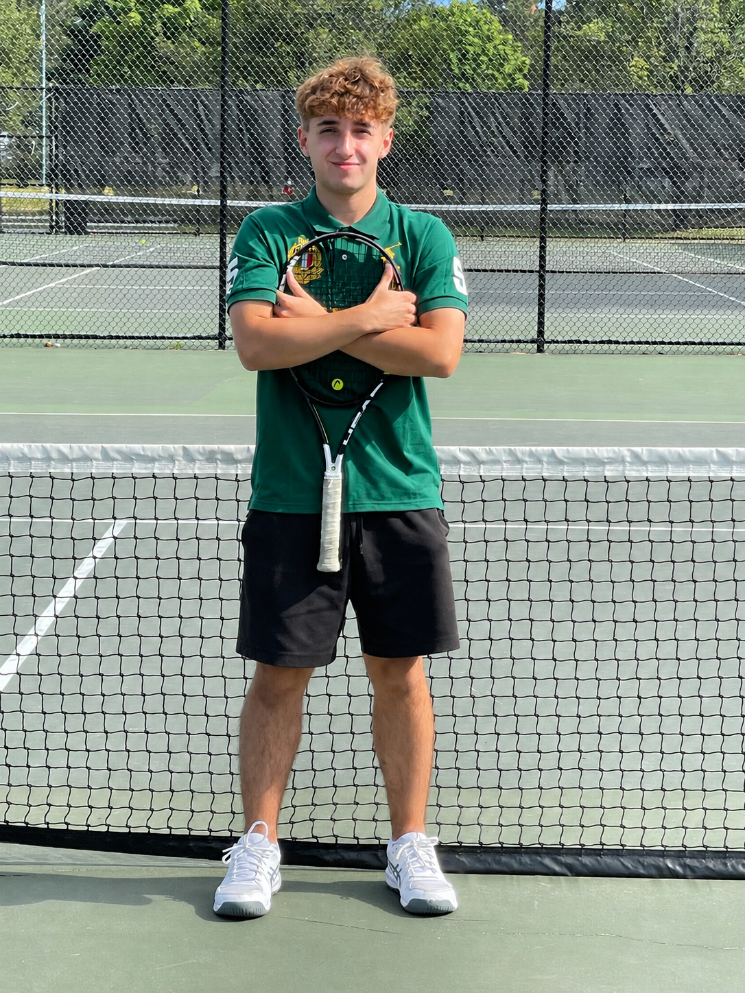 Daniel Anjoorian on a tennis court holding his racquet